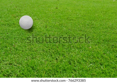 Golf ball on green grass of golf course.