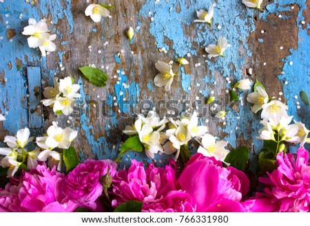Festive flower composition of peony and jasmine on the blue shabby wooden background. Overhead view. 