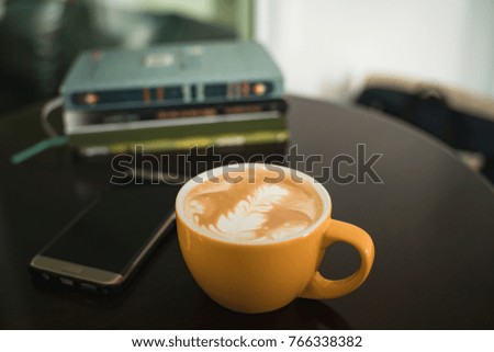 Latte art coffee in yellow cup by soft tone picture style