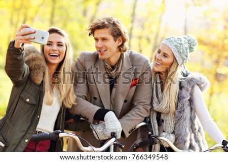 Picture showing group of friends on bikes in forest during fall time