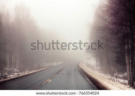 A deserted highway is in the fog