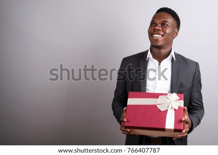 Studio shot of young African businessman wearing suit against white background