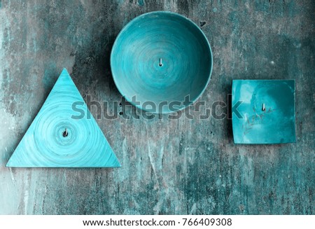 Decorative plates of various shapes on old grunge textured wall. Abstract toned vintage background