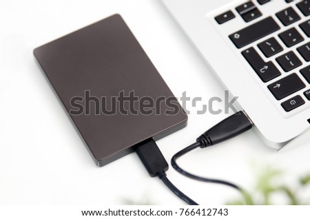 External backup disk hard drive connected to laptop. hard drive backup disk external computer data usb concept
