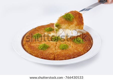 Turkish dessert kunefe, kunafa, kadayif with pistachio powder and cheese hot eaten a sweet Royalty-Free Stock Photo #766430533