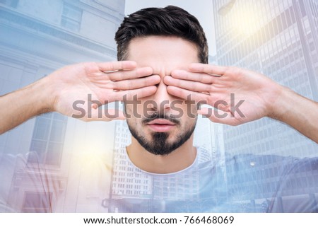 See nothing. Delighted young man wrinkling forehead and opening mouth while demonstrating his palms