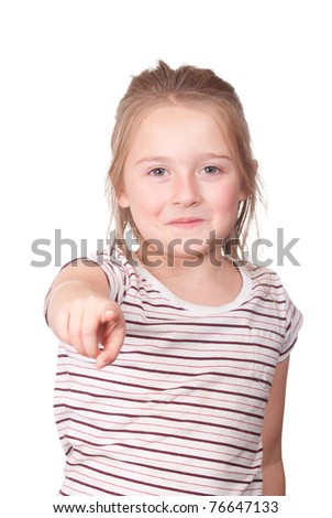 A photograph of a young girl pointing at something with a smirk on her face.
