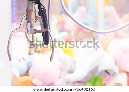 Claw Game or cabinet catches the doll.A mechanical arm selecting a random soft toy in a vending machine