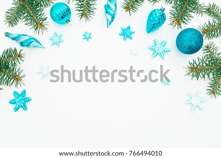 Christmas frame made of winter trees, blue decoration and snowflake on white background. Holiday frame. Flat lay, top view