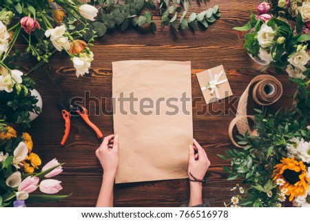 cropped image of florist holding empty sheet of paper in hands 