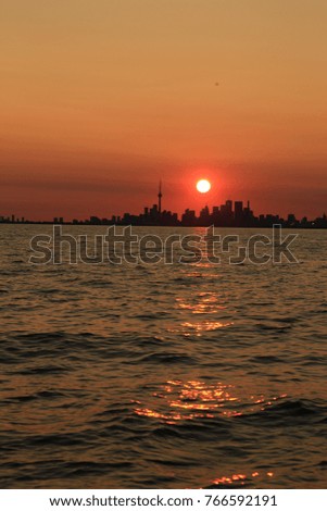 Sunset silhouette of Toronto City Skyline from the water.
