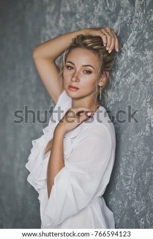 Beautiful portrait of a girl in a white gown with makeup and hair.