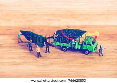 Miniature Worker Passenger Christmas Tree by Truck on Wooden floor ,Image for Christmas Holiday and Happy New Year Gift Celebration concept.vintage tone