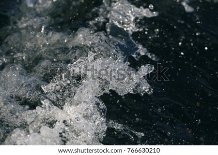 Close up high speed image of fresh clear water splashing off the hull of a sailboat in Lake Ontario.