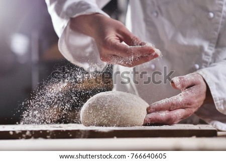 An experienced chef in a professional kitchen prepares the dough with flour to make the bio Italian pasta. the concept of nature, Italy, food, diet and bio. Royalty-Free Stock Photo #766640605