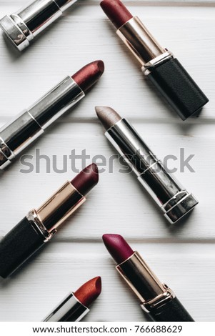 Lipsticks of different colors on wooden background 