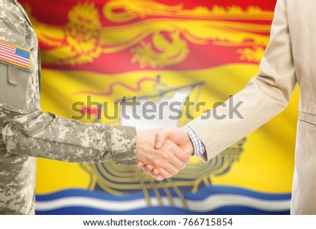 American soldier in uniform and civil man in suit shaking hands with certain  Canadian province flag on background - New Brunswick
