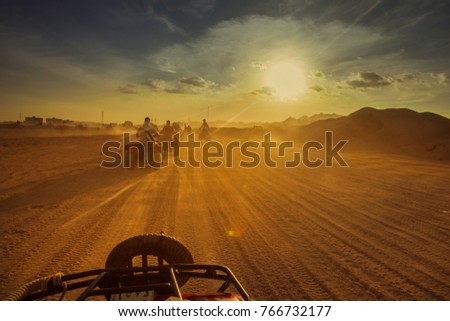 Group of tourist on ATV in Egypt desert during sundown. Toned, rework. Royalty-Free Stock Photo #766732177