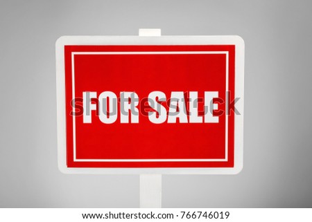"For sale" sign on grey background