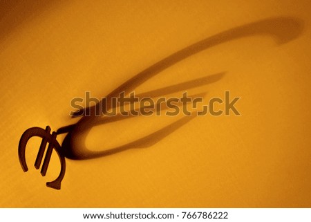 photo, image of sign euro silhouette with big long  shadow against the bright background                   