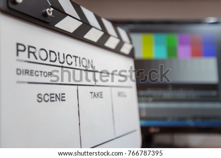 Movie clapper and editing room in background, cinema concept