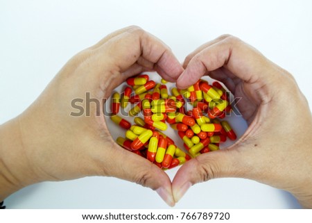 The hart sign hands hold the medicine capsule pill.