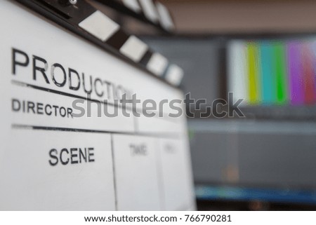 Movie clapper and editing room in background, cinema concept