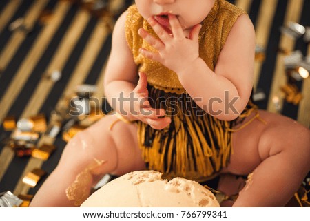 One year old baby girl celebrating her first birthday eating cake