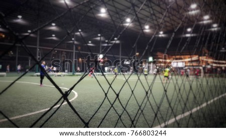Blurred and selective focus of indoor soccer field on holiday at night time