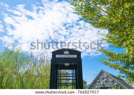 Telephone box is decorated at the restaurant in hotel with vintage style on sunny day and clear sky, surrounding with tree during holiday in Khao Yai, Thailand