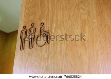 Toilet sign for male, female and disabled people on wooden wall
