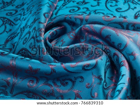 Fabric silk texture blue, flowers, abstract. a fine, strong, soft, lustrous fiber produced by silkworms in making cocoons and collected to make thread and fabric.