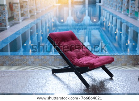 Swimming pool with clear blue water and  recliners