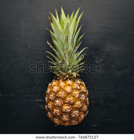 Pineapple on a wooden background. Top view. Free space for text.