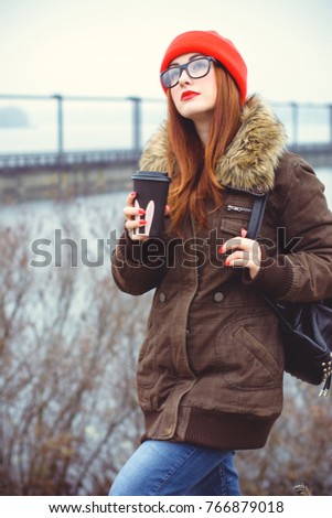 Melancholic teen hipster with depression mood. Lifestyle young people or student. Girl with cup of coffee in London cold weather