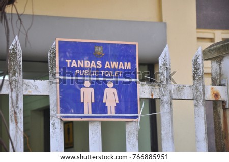 Public toilet sign on blue colored acrylic  sheet, English and Malaysian language under government sign