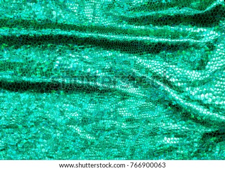 texture of silk fabric; background. green skin of the snake. shiny fabric