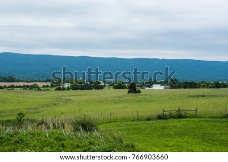 Beautiful view from a rest area, filled with grass, trees and mountains in the background