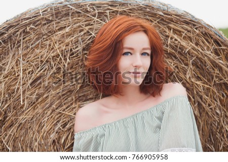 Red-hair girl on hay field