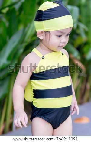 Little girl in swimsuit, bee polka