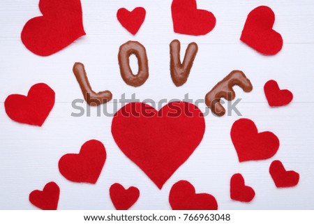 Love written by chocolate cookies alphabet with red hearts