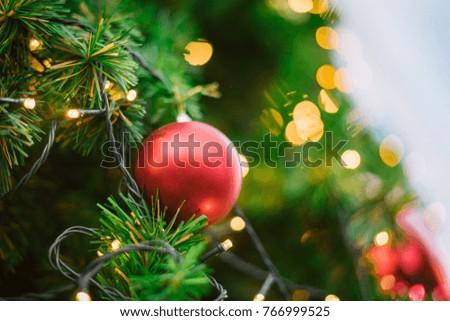 Closeup of red bauble. Decorated Christmas tree on blurred.