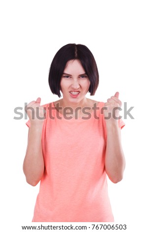 An evil girlshows an aggressive emotion, clenching her teeth and hands tightly into fists. Isolated.