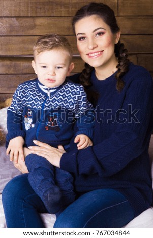 Pregnant happy young mother holding her son in winter