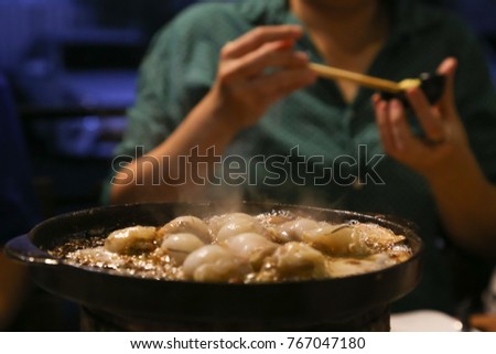 Blured picture of grilled shells with hot plate in a Korean restaurant
