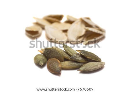 peel pumpkin seeds on focus and shells behind them
