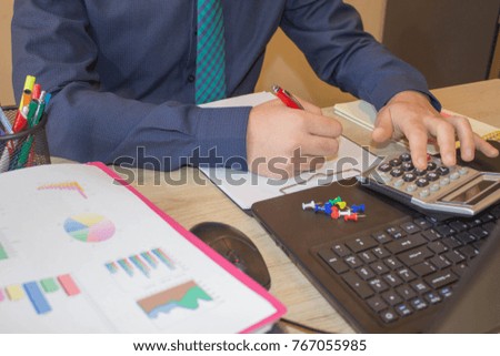 Business male Analyzing Statistics Financial Concept. The calculators, business owners, accounting and technology, business, computer, laptop, calculator and documents in the office