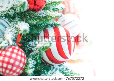 Colorful christmas decoration, red and white ball with snow on pine tree, a symbol of joyful happy moment on Christmas and New year's day. Defocused background. 