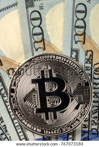 Coins bitcoin on a background of 100 American dollars close-up