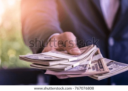businessman showing packs of international bank note